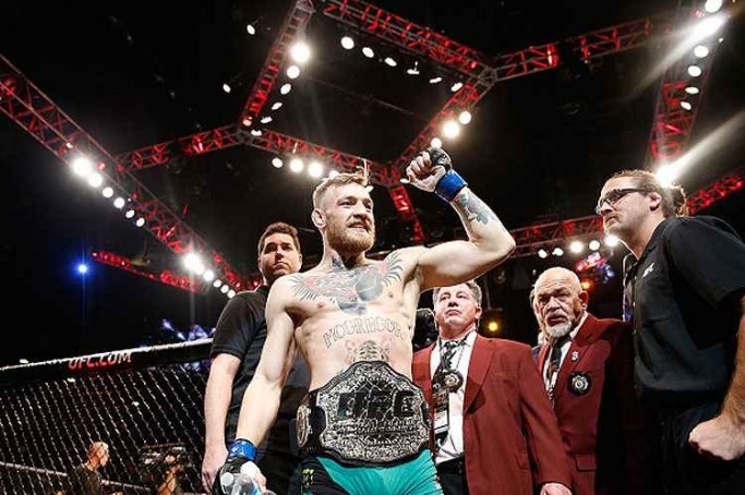 Orgulhoso, Conor McGregor exibe o cinturão dos penas do UFC, conquistado na luta contra José Aldo