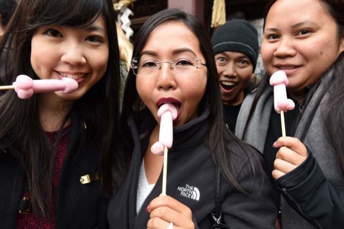 Women hold candy in the shape of phalluses at the Wakamiya Hachimangu Shrine during the Kanamara Festival in Kawasaki, a suburb of Tokyo on April 3, 2016.  More than 20,000 people gathered to enjoy the annual festival which Shinto believers carry giant phalluses through the streets. / AFP / TORU YAMANAKA