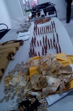 Armas, munições, dinheiro e drogas apreendidos pela Polícia Civil com os dois suspeitos de agirem no roubo a instituições financeiras.