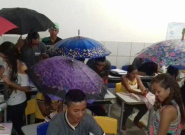 Alunos assistem aula usando guarda-chuvas em escola de Magalhães de Almeida