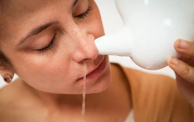 mulher desentupindo nariz com lavagem nasal