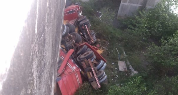 Carreta carregada de grãos cai da ponte da Estiva e condutor fica preso nas ferragens