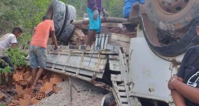 Caminhão carregado com material de construção tomba ao tentar subir ladeira