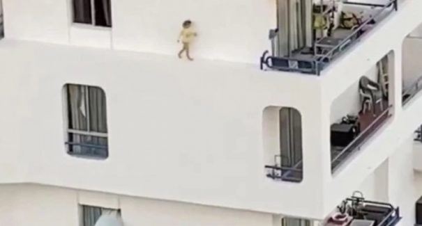 Criança caminha no parapeito do 5º andar de prédio